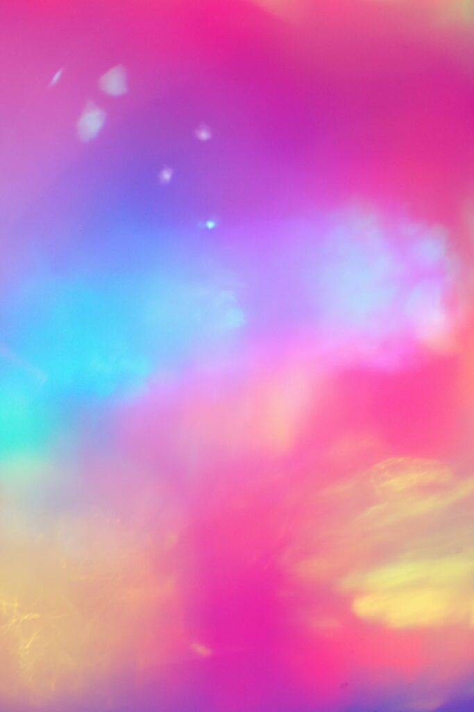 A dreamy, colorful abstract cloudscape with pastel rainbow hues evokes a fantasy landscape.